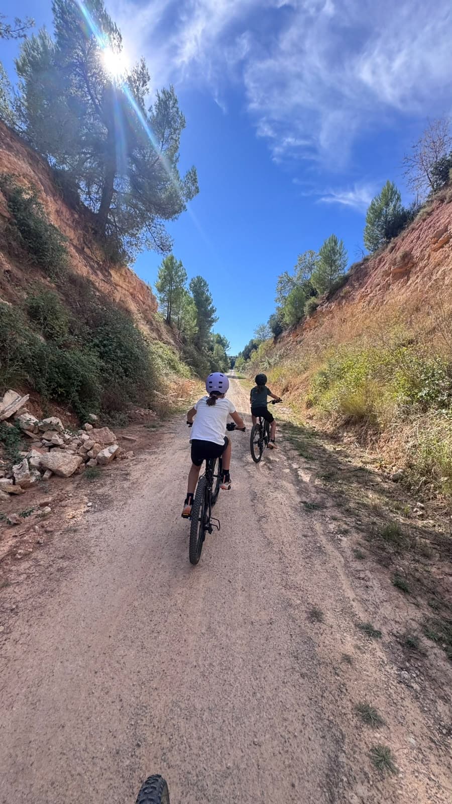 Niñas en bici por una trinchera de roca de la vía verde hacia Arnes